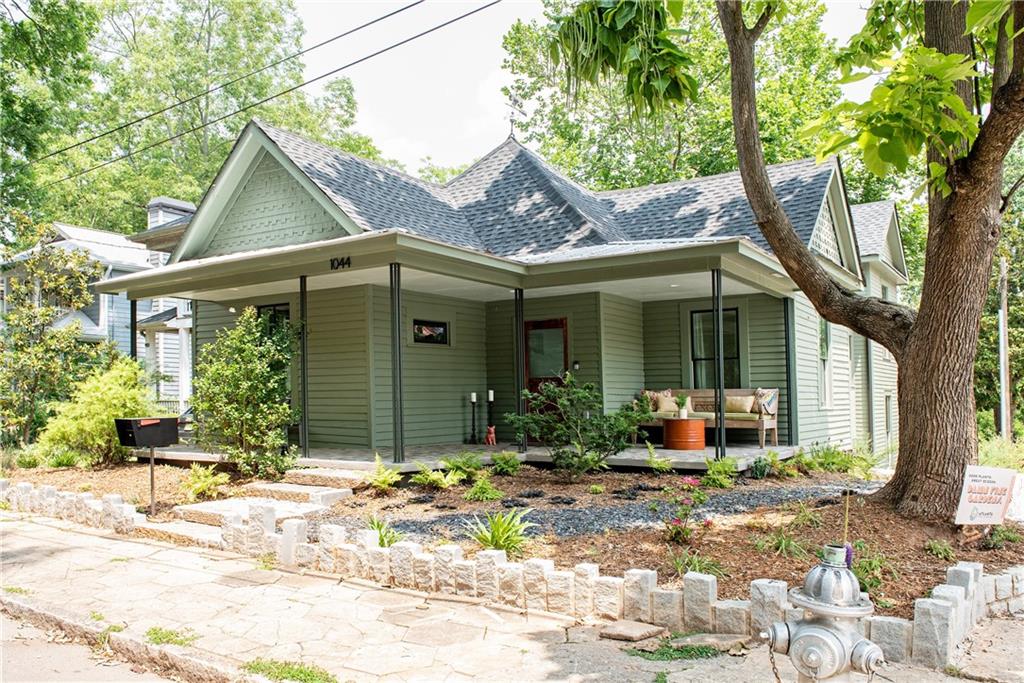 a view of house with yard and outdoor seating