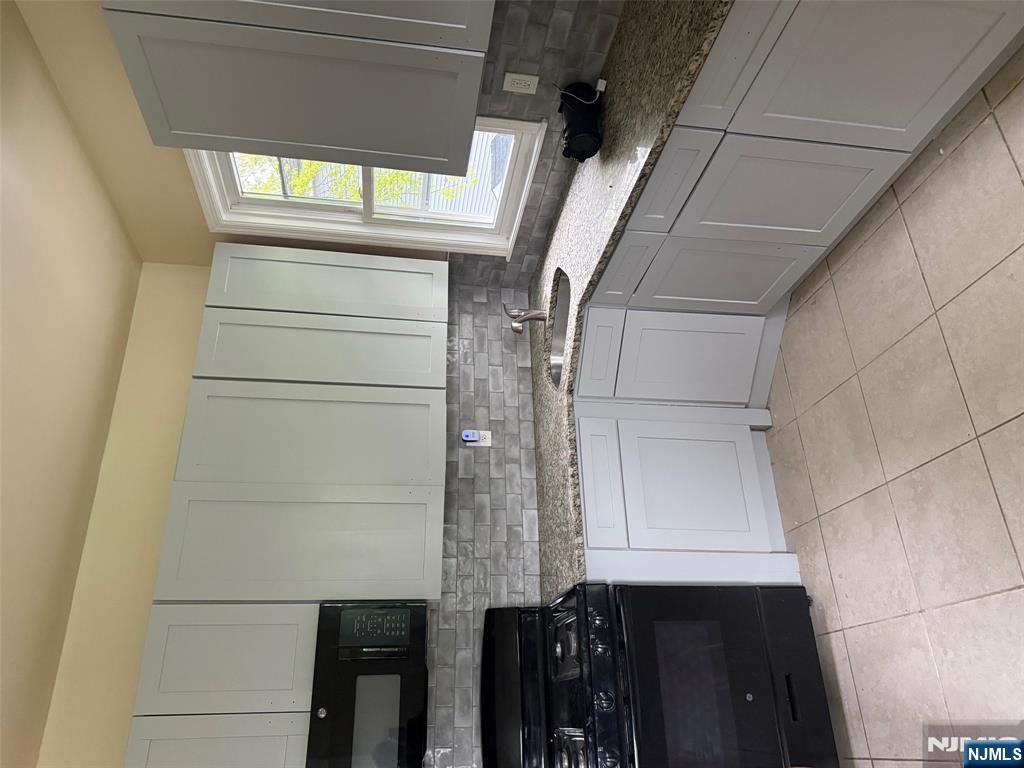 149-151 Scheerer Avenue, Unit 2 Newark, NJ 07112 - Photo 2 of 11 a kitchen with granite countertop a sink a stove and cabinets