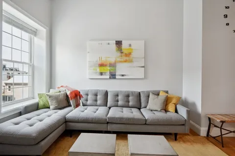 a living room with furniture and painting on the wall