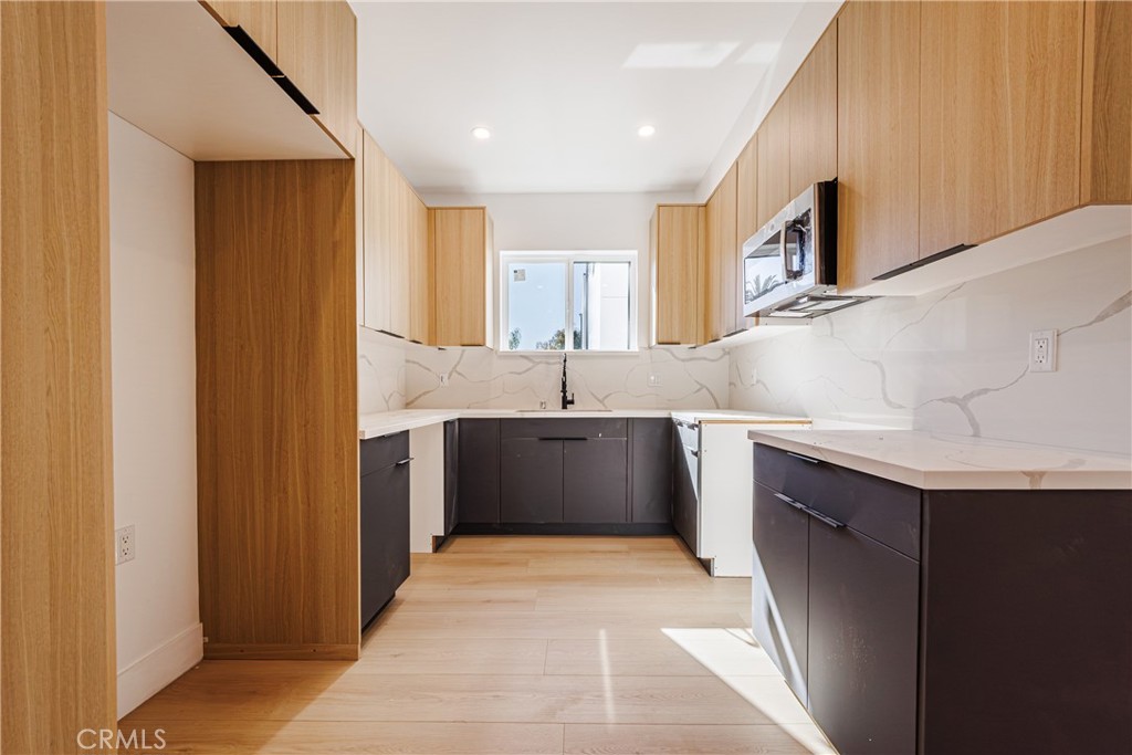 5209 20th Street, Unit A Los Angeles, CA 90016 - Photo 16 of 30 a kitchen with stainless steel appliances a sink stove and cabinets