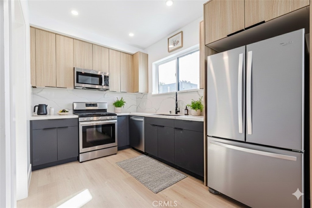 5209 20th Street, Unit A Los Angeles, CA 90016 - Photo 2 of 30 a kitchen with stainless steel appliances a refrigerator sink and a stove