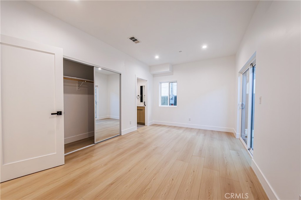 5209 20th Street, Unit A Los Angeles, CA 90016 - Photo 8 of 30 an empty room with wooden floor and windows