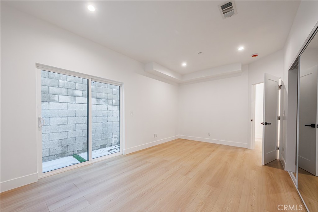 5209 20th Street, Unit A Los Angeles, CA 90016 - Photo 9 of 30 an empty room with wooden floor and windows