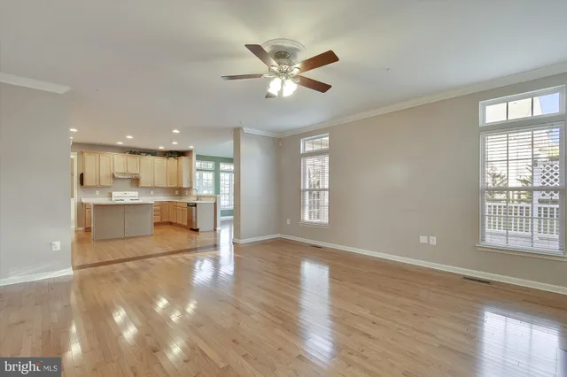 a view of an empty room with window and wooden floor