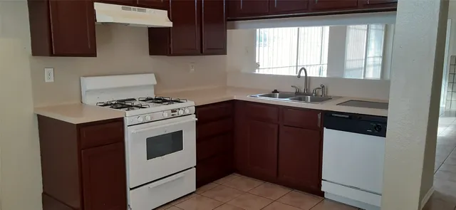a kitchen with stainless steel appliances a sink stove and cabinets