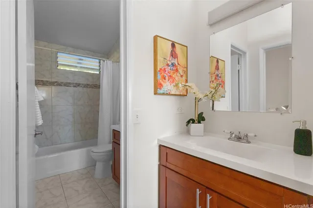 a bathroom with a granite countertop sink a toilet and shower