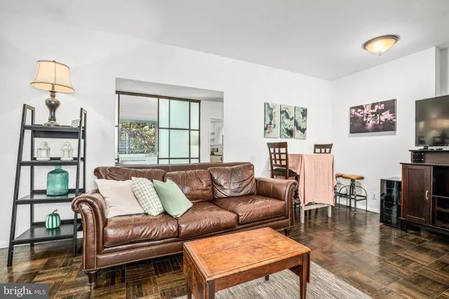 a living room with furniture and a flat screen tv with wooden floor