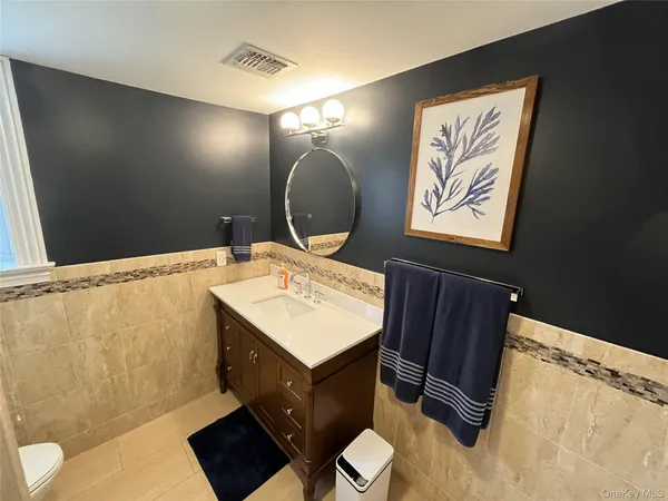 a bathroom with a sink vanity mirror and toilet