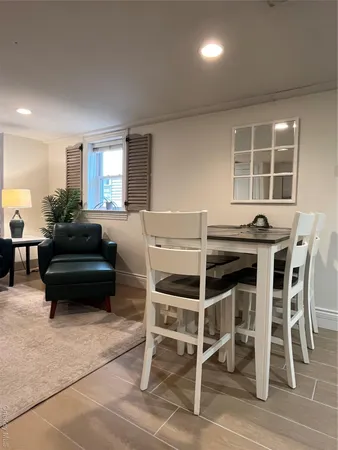 a living room with a dining table and chairs with wooden floor