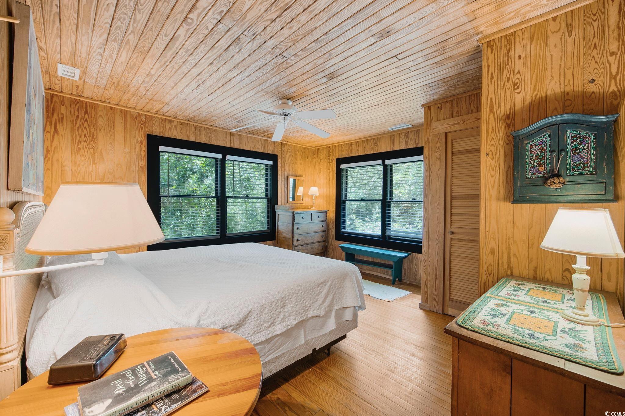 496 Myrtle Avenue Pawleys Island, SC 29585 - Photo 31 of 40 Bedroom featuring multiple windows, wooden walls, and wood-type flooring