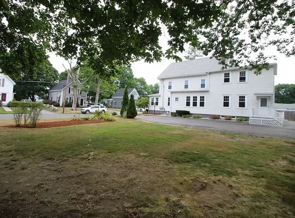 a row of trees and patio in front of house