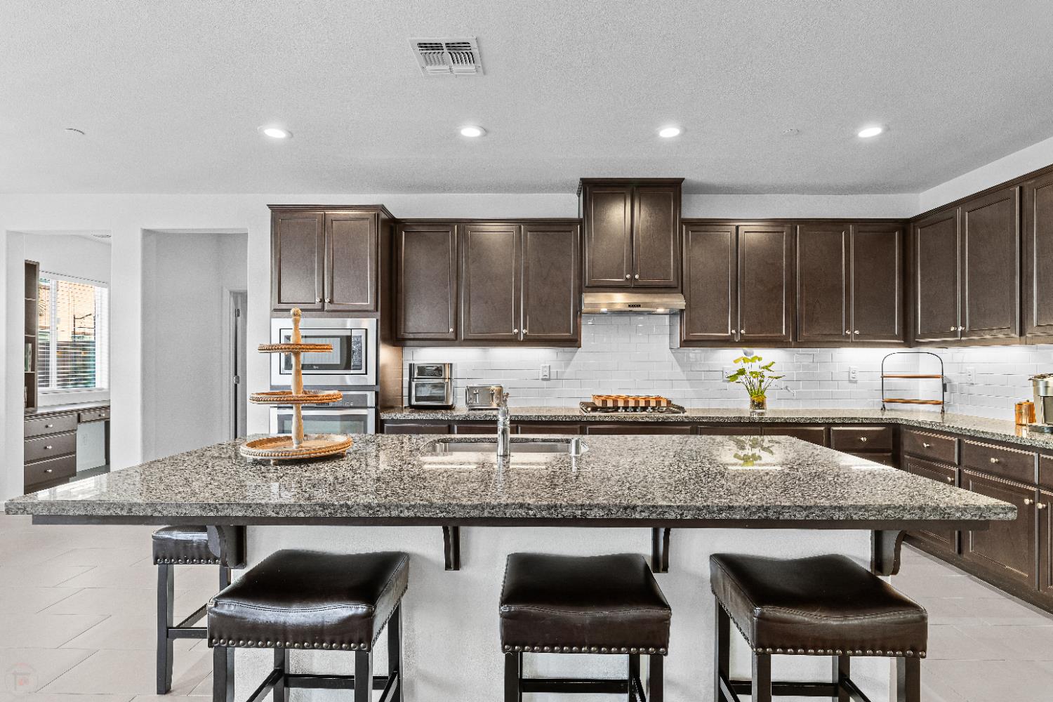 2305 Augusta Avenue Tracy, CA 95377 - Photo 20 of 91 a kitchen with kitchen island granite countertop wooden cabinets and a granite counter tops