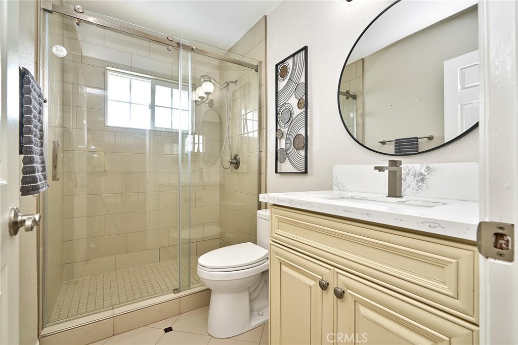 8652 Los Coyotes Drive Buena Park, CA 90621 - Photo 51 of 72 a bathroom with a sink a mirror a glass door and shower