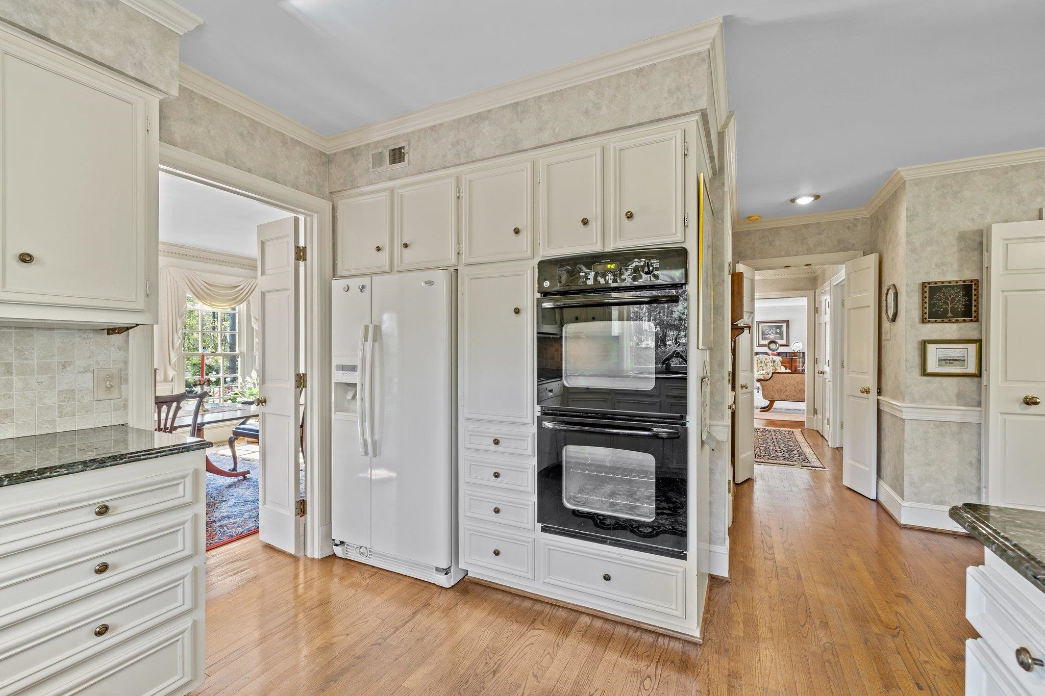 3608 Dover Road Durham, NC 27707 - Photo 26 of 60 a kitchen with stainless steel appliances white cabinets and wooden floors