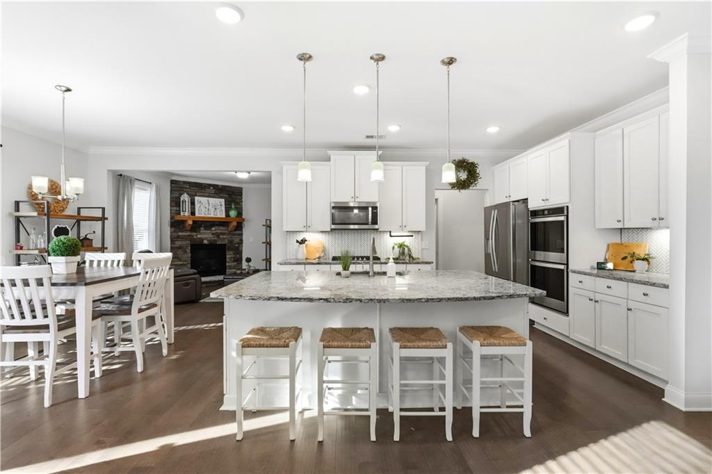 8745 Hightower Ridge Ball Ground, GA 30107 - Photo 2 of 36 a kitchen with stainless steel appliances granite countertop a table and chairs in it