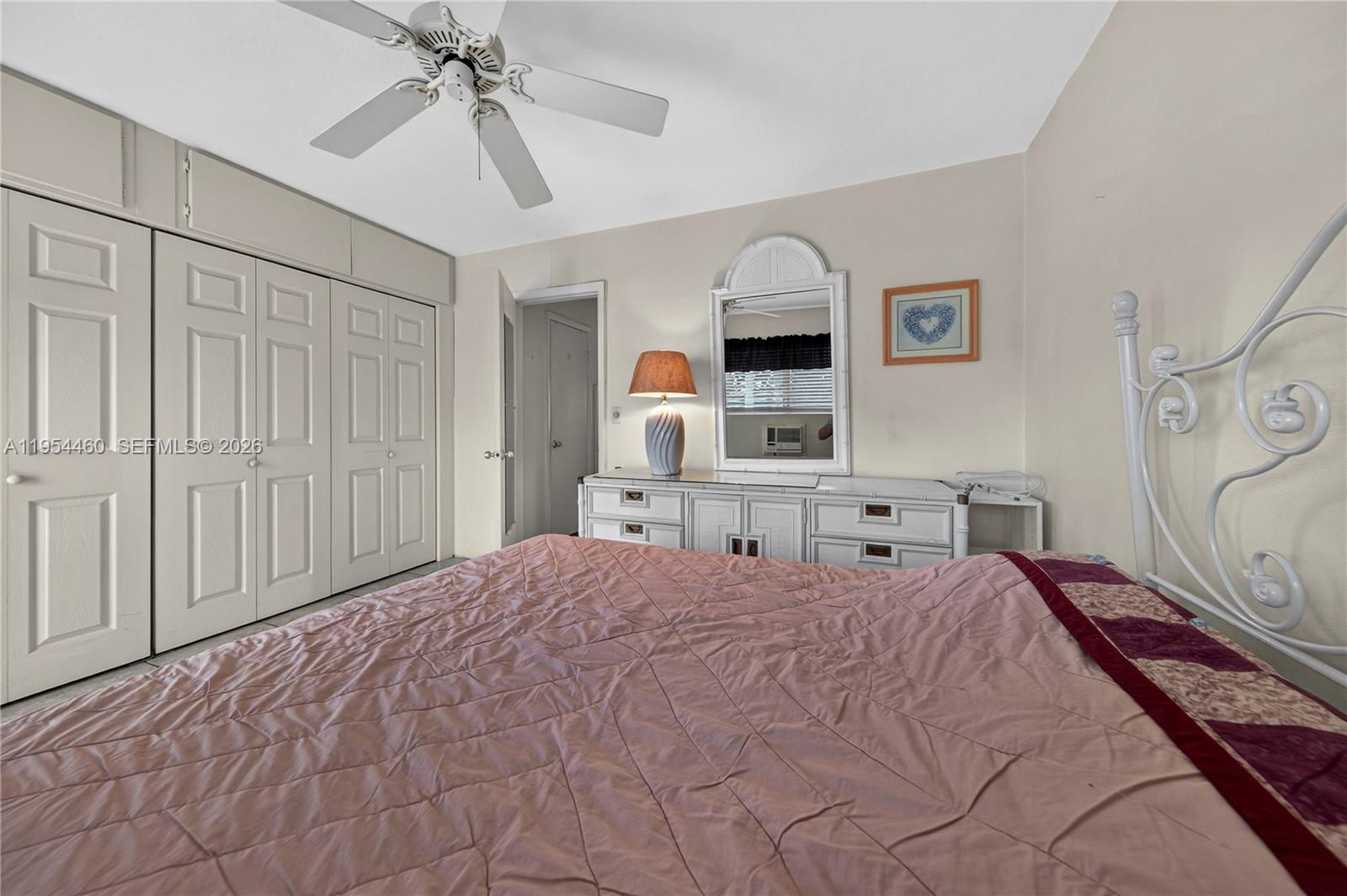 331 East McNab Road, Unit 226 Pompano Beach, FL 33060 - Photo 20 of 29 a bedroom with a large bed and a chandelier