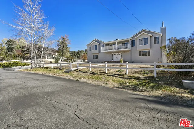 an aerial view of a house with a yard and large trees