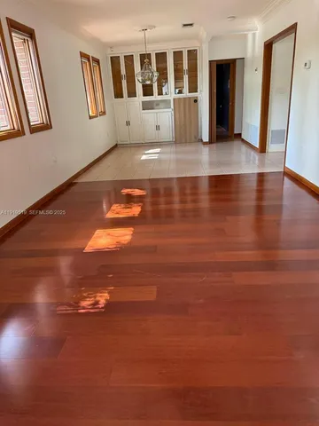a view of empty room with wooden floor and windows