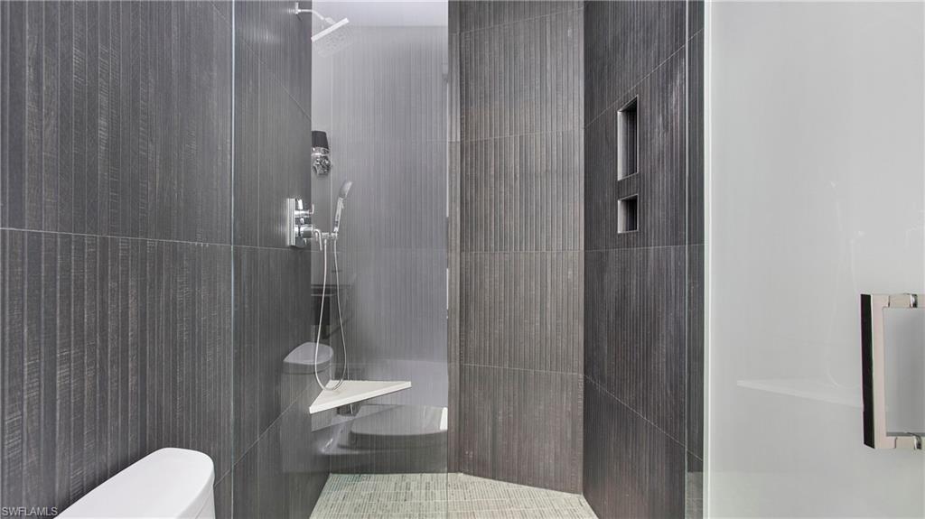 1798 Holiday Lane Naples, FL 34104 - Photo 24 of 47 Bathroom featuring tiled shower and tile walls