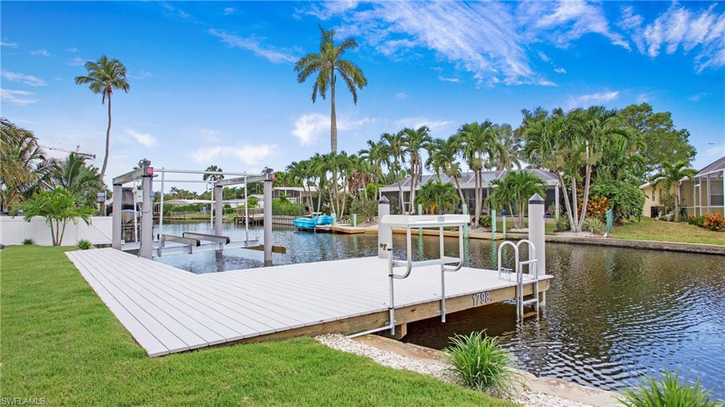 1798 Holiday Lane Naples, FL 34104 - Photo 33 of 47 Dock area with boat lift, a water view, and a yard