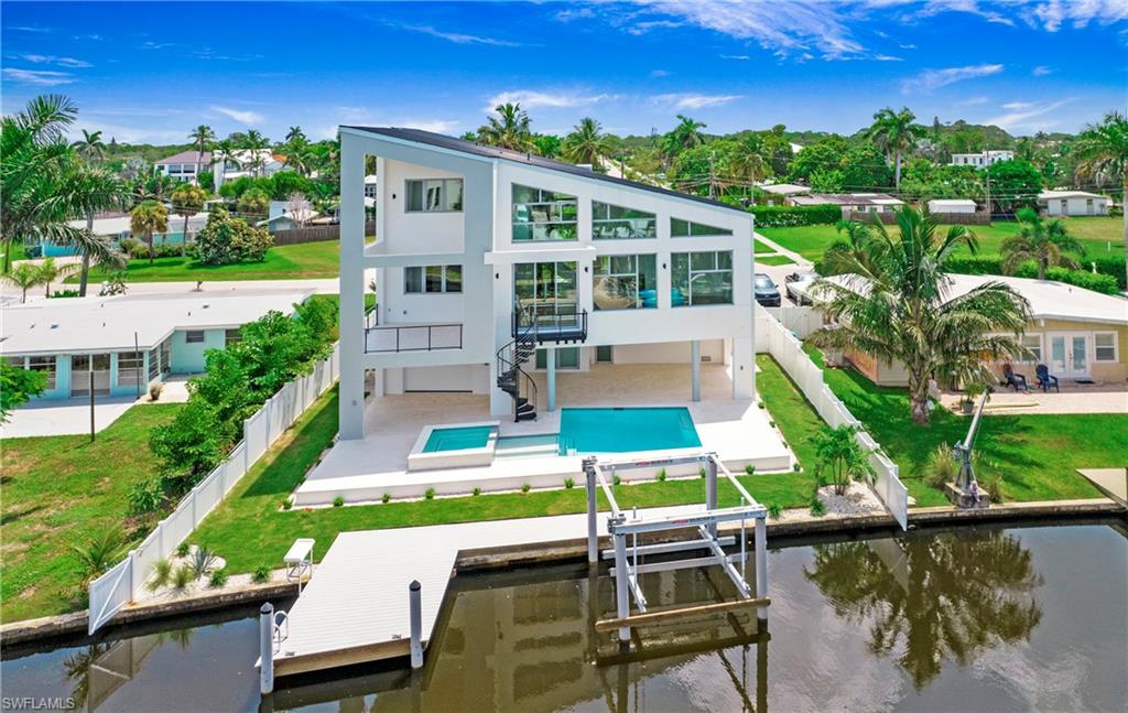 1798 Holiday Lane Naples, FL 34104 - Photo 47 of 47 Back of house featuring a fenced backyard, a water view, boat lift, stairway, and a patio area