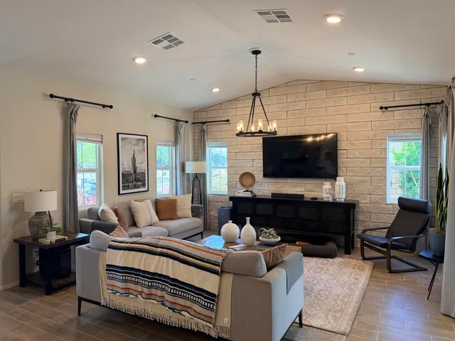 a living room with furniture a flat screen tv and a large window