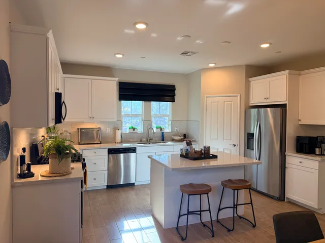 a kitchen with a table chairs refrigerator and microwave