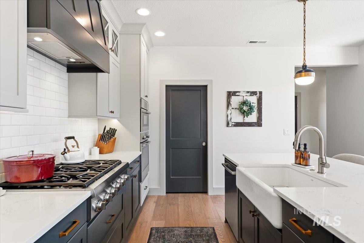3794 South Single Tree Avenue Boise, ID 83716 - Photo 21 of 50 Gourmet kitchen featuring a gas range, subway tile backsplash, white countertops, built-in wall oven, and a farmhouse sink with a contemporary faucet