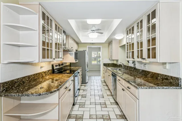 a large kitchen with stainless steel appliances granite countertop a stove and a sink