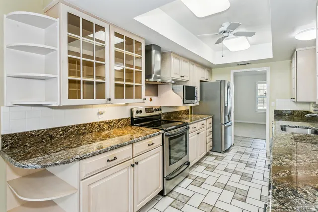 a kitchen with stainless steel appliances granite countertop a stove a sink and a refrigerator