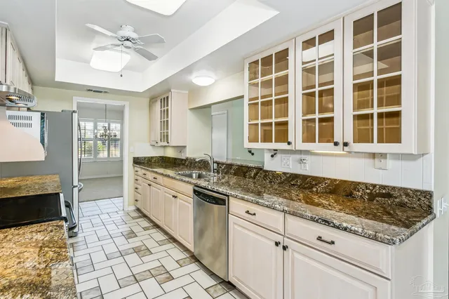 a kitchen with granite countertop a sink and a stove