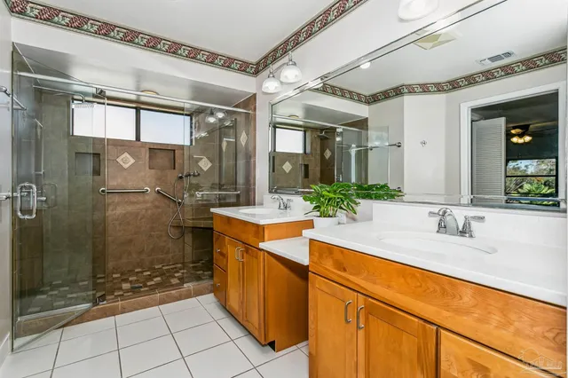 a spacious bathroom with a granite countertop sink mirror and shower