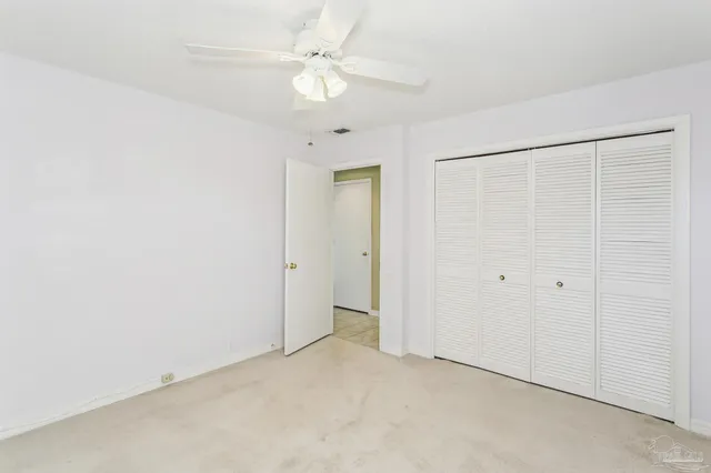an empty room with a ceiling fan and a window