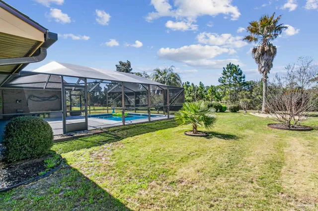 a view of a house with swimming pool and a yard