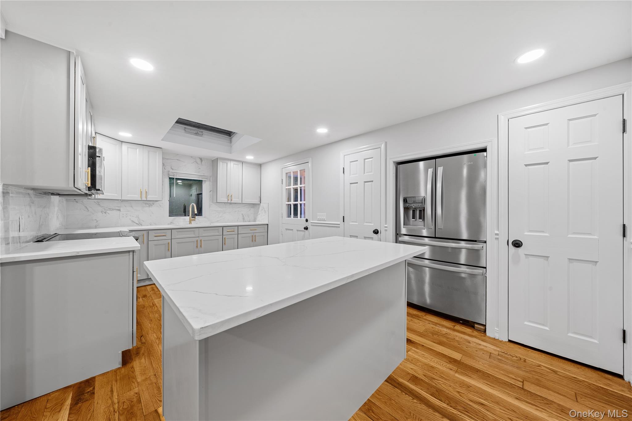 57 Eastwood Road Miller Place, NY 11764 - Photo 12 of 49 a large white kitchen with stainless steel appliances granite countertop a refrigerator and a sink