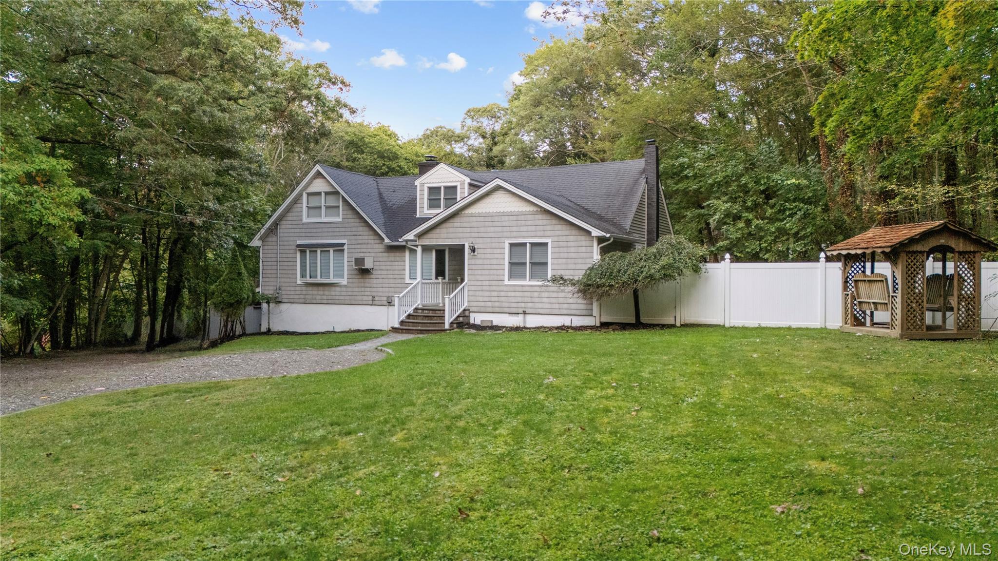 57 Eastwood Road Miller Place, NY 11764 - Photo 3 of 49 a front view of a house with a garden and yard