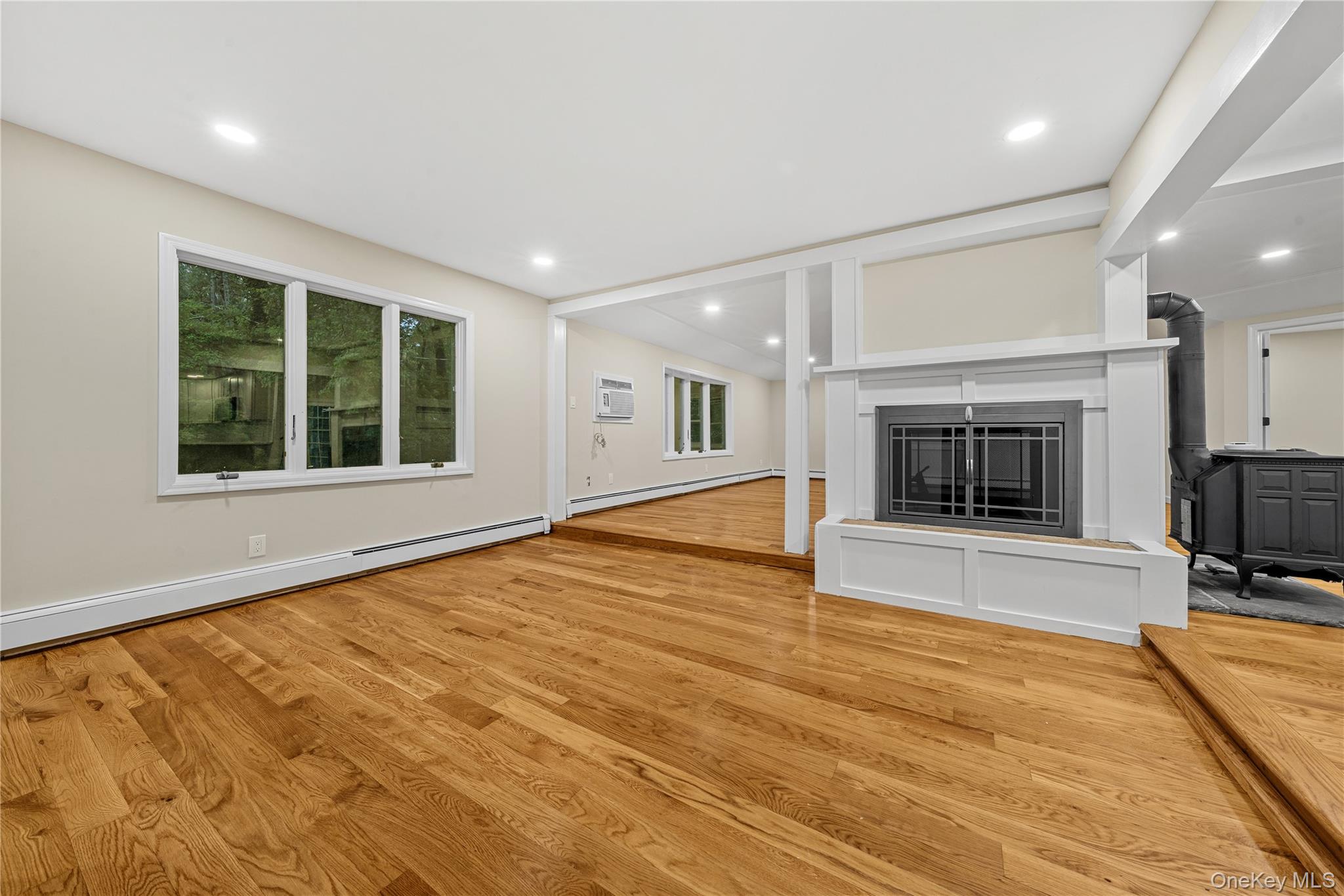 57 Eastwood Road Miller Place, NY 11764 - Photo 5 of 49 a view of an empty room with a fireplace and a window