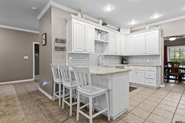 a kitchen with cabinets and chairs