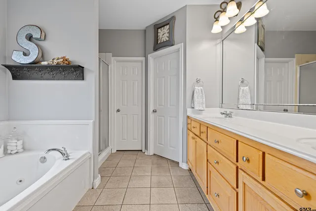 a spacious bathroom with a tub sink and mirror
