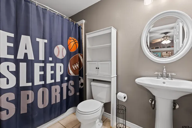 a bathroom with a toilet a sink and a mirror