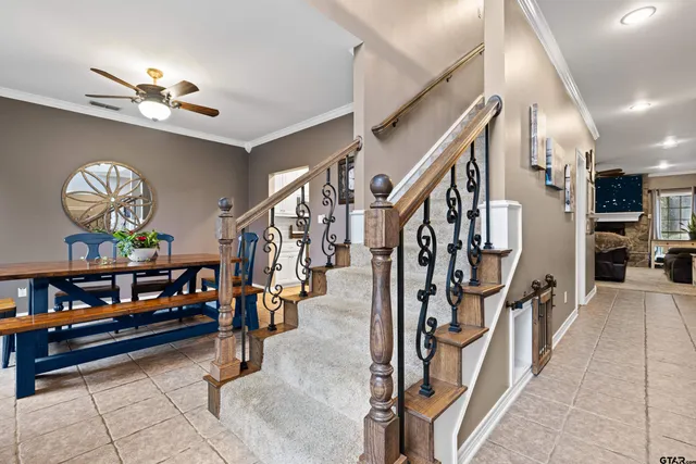 a view of staircase with lots of frames on wall and a chandelier