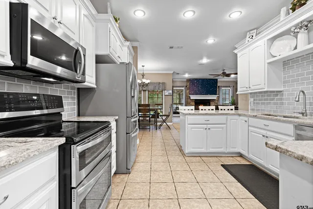 a kitchen with stainless steel appliances granite countertop a stove a sink and a microwave