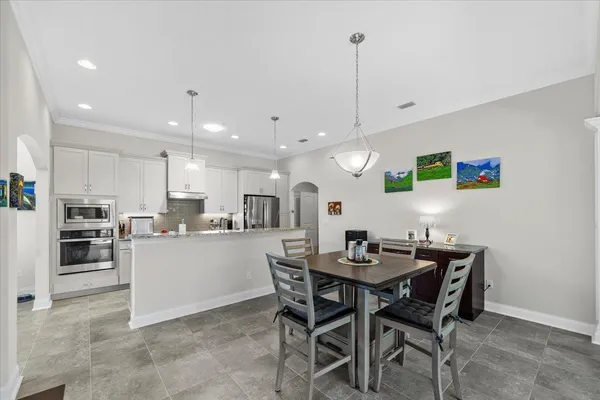 a kitchen with a dining table chairs and stainless steel appliances