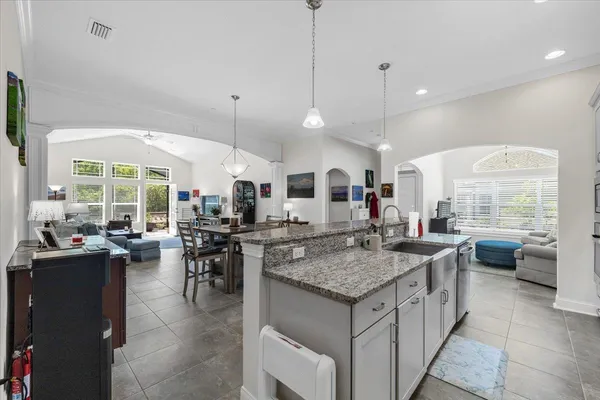 a kitchen with a counter top space a sink appliances and living room view