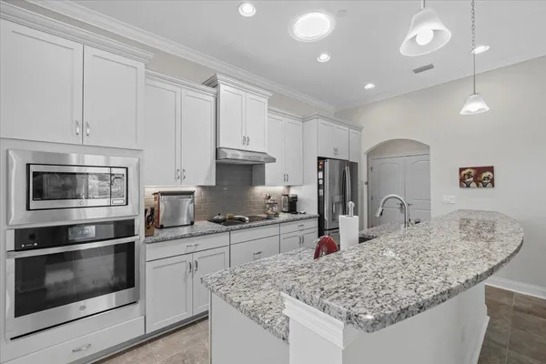 a kitchen with stainless steel appliances granite countertop a sink stove and cabinets