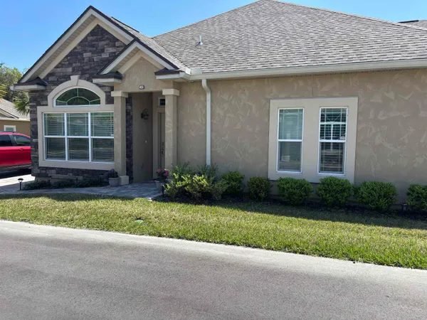 a front view of a house with a garden and yard