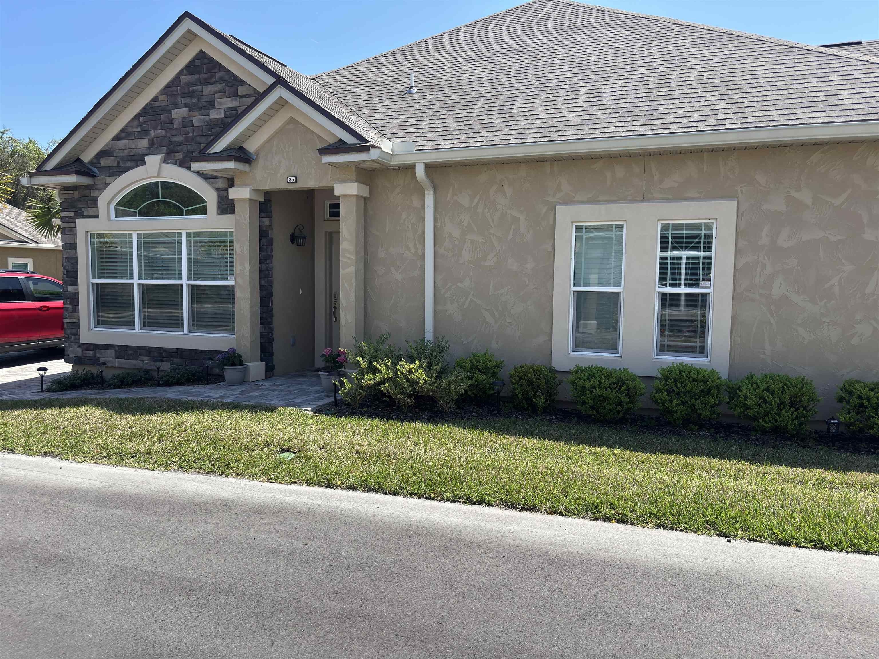35 Timoga Trail St. Augustine, FL 32084 - Photo 3 of 52 a front view of a house with a garden and yard