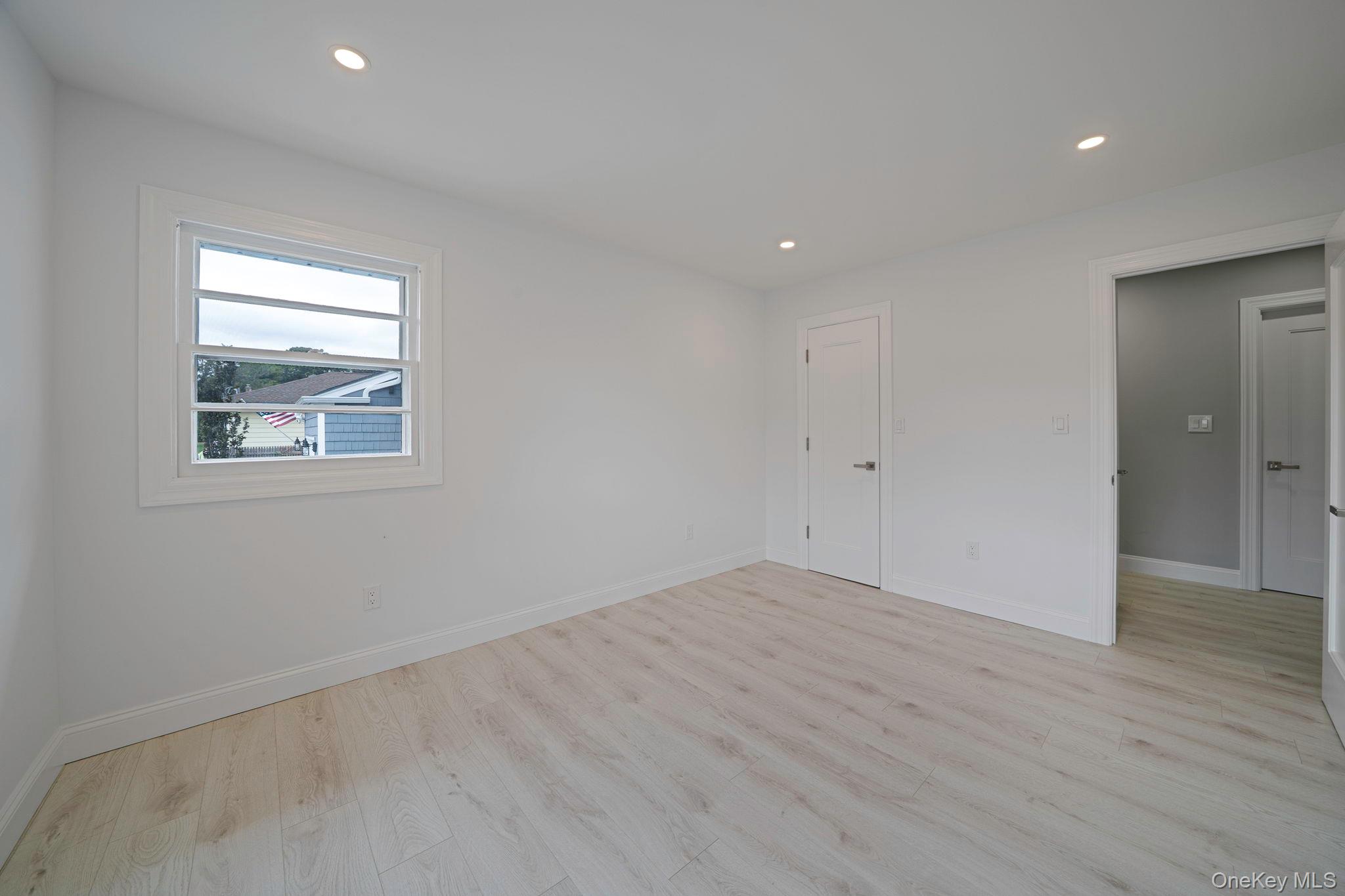 827 Aberdeen Road Bay Shore, NY 11706 - Photo 28 of 40 an empty room with wooden floor and windows