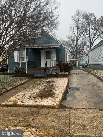 a front view of a house with a yard covered with snow