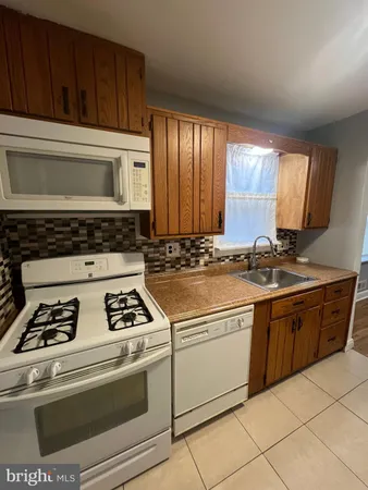 a kitchen with granite countertop a stove sink and cabinets